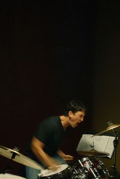 a man playing drums in front of a drum set