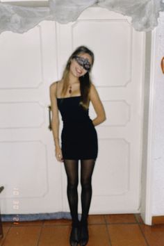 a young woman wearing tights and stockings posing for the camera in front of a door