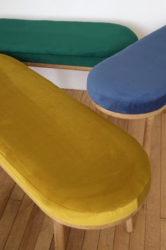 two different colored benches sitting on wooden floors