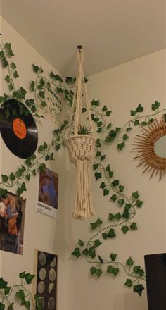 the wall is decorated with plants and vinyl record player's, which are hanging from strings