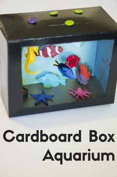 the cardboard box is filled with different types of sea animals and fish in an aquarium