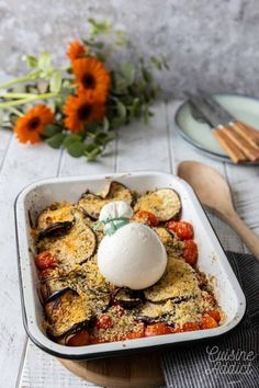 an egg on top of some vegetables in a casserole dish