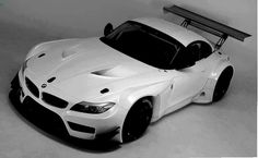 a white sports car is shown in this black and white photo