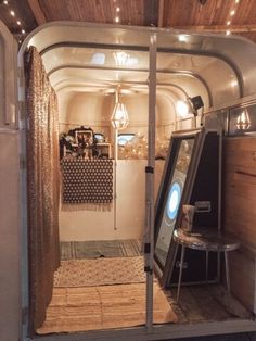 an inside view of a bus with lights on the ceiling and some mirrors in it