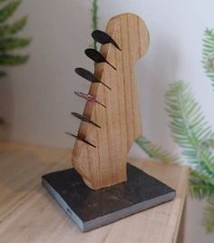 a wooden sculpture with knives sticking out of it's back end on top of a table