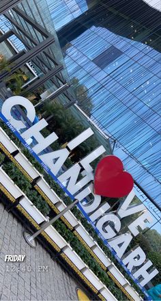 a large sign that says change park in front of a glass building with a red heart on it