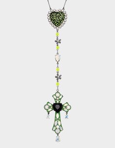 a green and white necklace with a cross hanging from it's center, on a chain