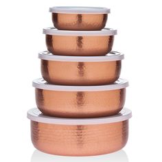 five copper colored bowls stacked on top of each other