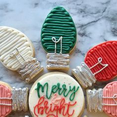 decorated cookies with merry and bright frosting on a marble counter top, surrounded by other cookie decorations