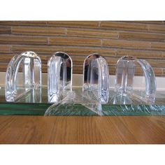 three clear glass pieces sitting on top of a wooden table