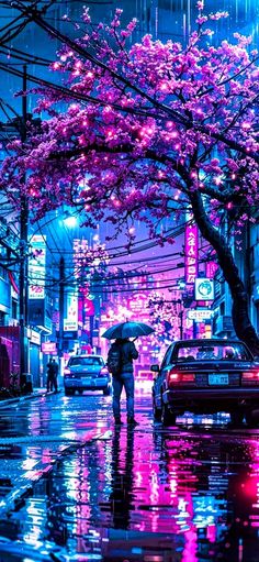 a person with an umbrella is standing in the rain under a pink blossoming tree