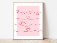 a pink poster with hearts hanging on the wall