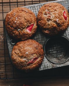 three muffins sitting on top of a cooling rack next to a cupcake tin