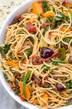 a white bowl filled with pasta and vegetables