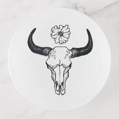 a white plate with a bull skull and flower on it