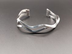 "This sterling silver cuff bracelet is made of two strands of thick silver wire in a triangular shape (flat on the back and comes to a point on the front) that have been shaped into a wavy design. The simple style would look great on its own or as part of a bracelet stack. It is in very good condition, with minimal surface wear. It has an imperfect shape due to the nature of handmade items. It is 1/2\" wide at the ends (width varies throughout the bracelet because of the design) and 5½\" long with a 1\" gap. The size is somewhat adjustable by gently stretching or squeezing but would fit a small to medium wrist. It is marked 925 on the inside of one of the ends." Minimal Surface, Wavy Design, Beaded Bracelet Patterns, Sterling Silver Cuff Bracelet, Minimalist Bracelet, Sterling Silver Cuff, Silver Cuff Bracelet, Silver Cuff, Bracelet Stack