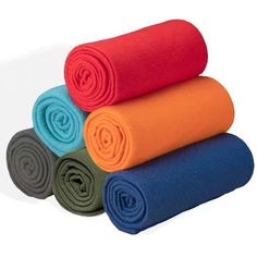 four rolled up yoga mats stacked on top of each other in different colors and sizes