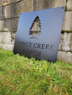 a sign that reads fancy creek ranch in front of a brick wall and grass area