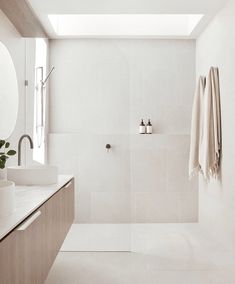 a white bathroom with two sinks and a shower