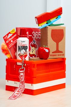 an assortment of items sitting on top of a red box with a ribbon around it