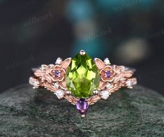 a ring with an oval cut green and purple stone in the center, surrounded by diamonds