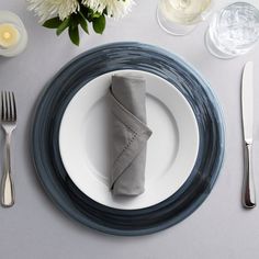 a place setting with silverware and white flowers on the table, along with napkins