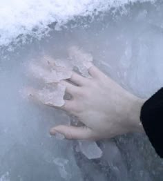 a person's hand holding something in the ice