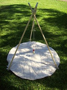 an outdoor swing set in the grass with two sticks sticking out of it's top