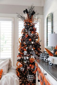 a halloween tree decorated with black and orange decorations