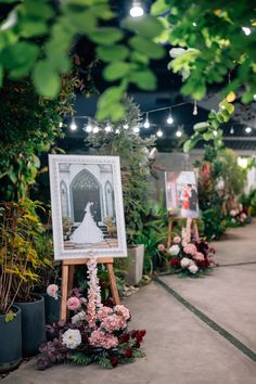 an outdoor ceremony with flowers and pictures on easels