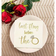 a white plate topped with red roses next to a sign that says, last fling before the o