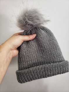 This winter hat is perfect for a young child to wear outside in the cold.   Machine knitted by me. Pom pom is secured around a button on top of hat for easy removal for washing. Measures 7 inches tall when brim is folded up.  And approximately 18 inches wide. Perfect for 2 to 4 year old.  Maybe even 5 year old. Warm Gray Bonnet One Size Fits Most, Adjustable Warm Gray Beanie, Cozy Warm Gray Beanie, Warm Gray Bonnet Cap, Cozy Gray Warm Hat, Gray Beanie Hat For Winter, Gray Cold Weather Hat, One Size Fits Most, Gray Knitted Hat For Cold Weather, Gray Hats For Cold Weather