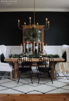 a dining room with black walls and white chairs