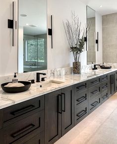 a large bathroom with double sinks and mirrors on the wall, along with marble counter tops