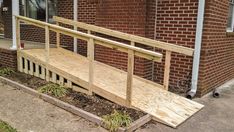 a wooden bench sitting in front of a brick building