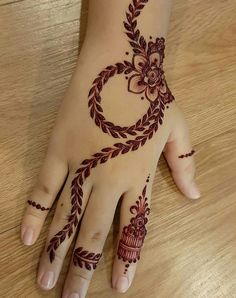 a hand with henna on it sitting on top of a wooden table