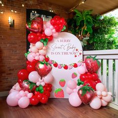 a strawberry themed birthday party is on the way with balloons and strawberries as decorations