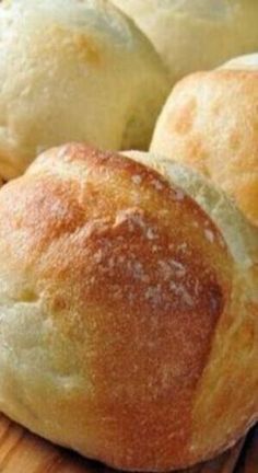 bread rolls sitting on top of a wooden cutting board