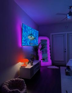 a living room with purple lighting and a fish on the tv