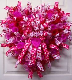 a pink and white wreath with hearts on it