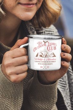 a woman holding a coffee mug in her hands