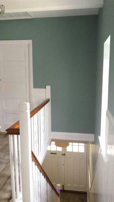 an empty staircase leading up to the second floor with blue walls and white railings