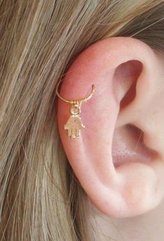 a close up of a person's ear with an earring attached to it