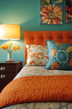 a bed with two paintings on the wall above it and a lamp next to it