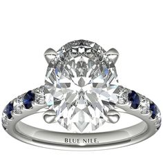 an oval cut diamond engagement ring with pave set diamonds on the band and side stones