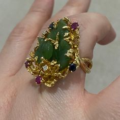 "Elevate your style with this exquisite 18k Italian-made gold ring, weighing 16.22g and adorned with enchanting gemstones including vibrant green jade leaves, lustrous ruby, sparkling sapphire, and dazzling diamonds. Its unique design captures the essence of elegance and sophistication, making it a statement piece for any occasion." Luxury Green Multi-stone Emerald Ring, Fine Jewelry Green Multi-stone Emerald Ring, Green Multi-stone Emerald Ring Fine Jewelry, Green Multi-stone Marquise Jewelry, Luxury Green Emerald Ring With Gemstone Accents, Green Multi-stone Gemstones Fine Jewelry, Green Multi-stone Fine Jewelry Gemstones, Green Multi-stone Gemstones In Fine Jewelry Style, Green Multi-stone Gemstones For Anniversary