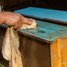 a person is cleaning the outside of a wooden box