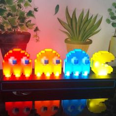 three lit up elephants sitting on top of a table next to a potted plant