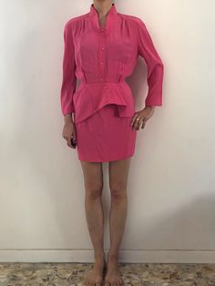 Wow! Amazing Thierry Mugler hot pink suit set.  Very cute Barbie energy! The suit is made amazingly, like all Mugler pieces. Super stitching and construction - couture quality.  The fabric is a heavy rayon and acetate with a shiny satin interior. It has a great heavy weight with a wonderful drape.  The jacket has a 1940's style.  Kimono sleeves with gathers at the shoulders.  The neckline is deep and open with a band collar.  Pink plastic snaps up the front.  Asymmetrical reinforced peplum! Also one cool Mugler pocket on the peplum.  Mini skirt has a high waist and a fitted shape.  Pink plastic snaps up the back.  Waist band with V detail.  Both pieces are unlined. The fabric is satin on the inside.  Label Thierry Mugler Paris, Skirt has the size 38, 67% acetate, 33% viscose. Dry Clean onl Chic Pink Long Sleeve Sets, Chic Fitted Pink Sets, Spring Pink Skirt Suit For Party, Chic Pink Skirt Suit For Formal Events, Chic Pink Skirt Suit For Formal Occasions, Pink Long Sleeve Skirt Suit For Spring, Pink Long Sleeve Skirt Suit For Work, Spring Pink Long Sleeve Skirt Suit, Chic Pink Party Skirt Suit