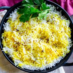 a pan filled with rice and cilantro garnished with parsley on top